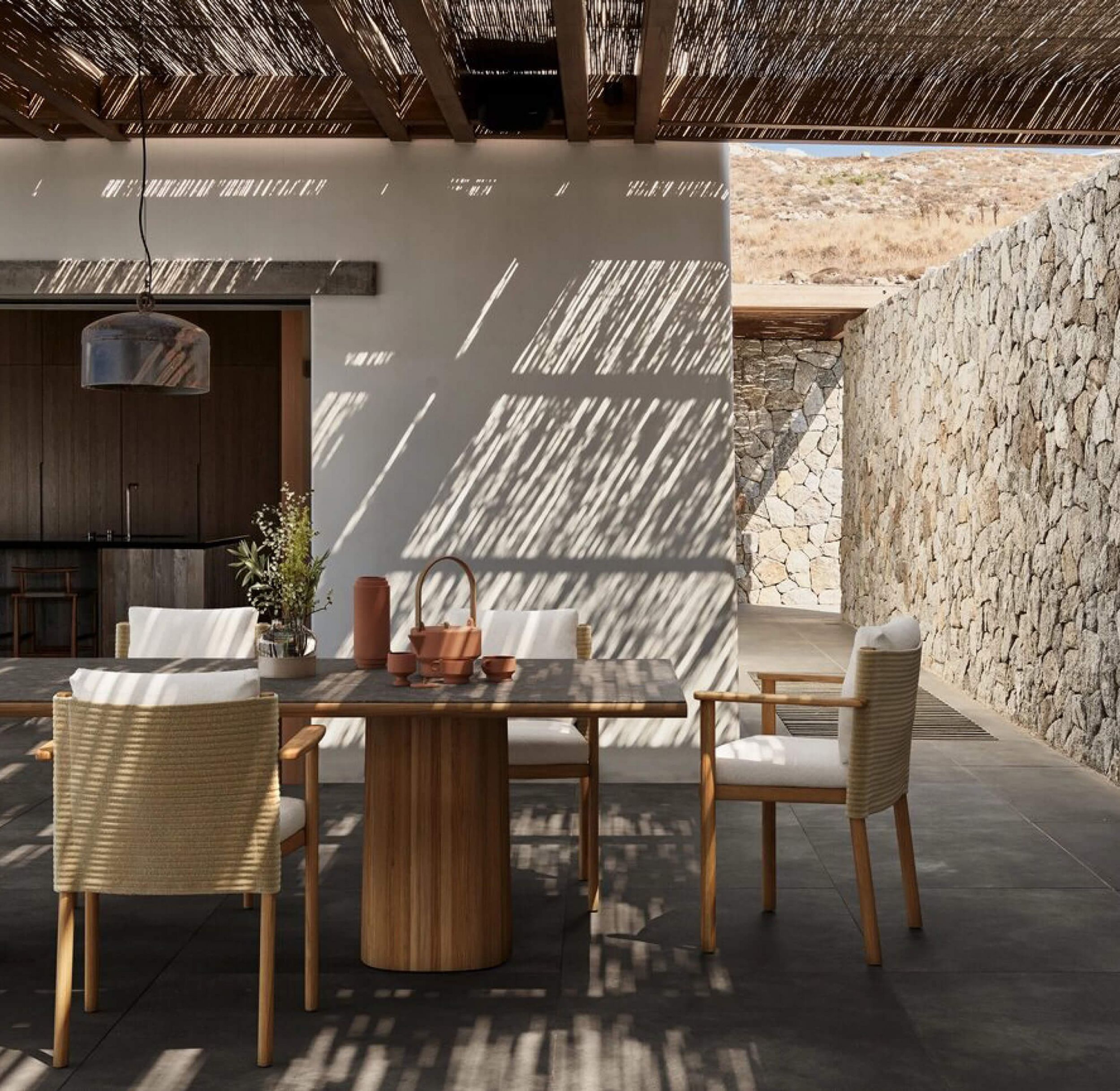 Table de repas extérieur en teck et en céramique aux lignes généreuses collection Giro par Kettal à Bonifacio