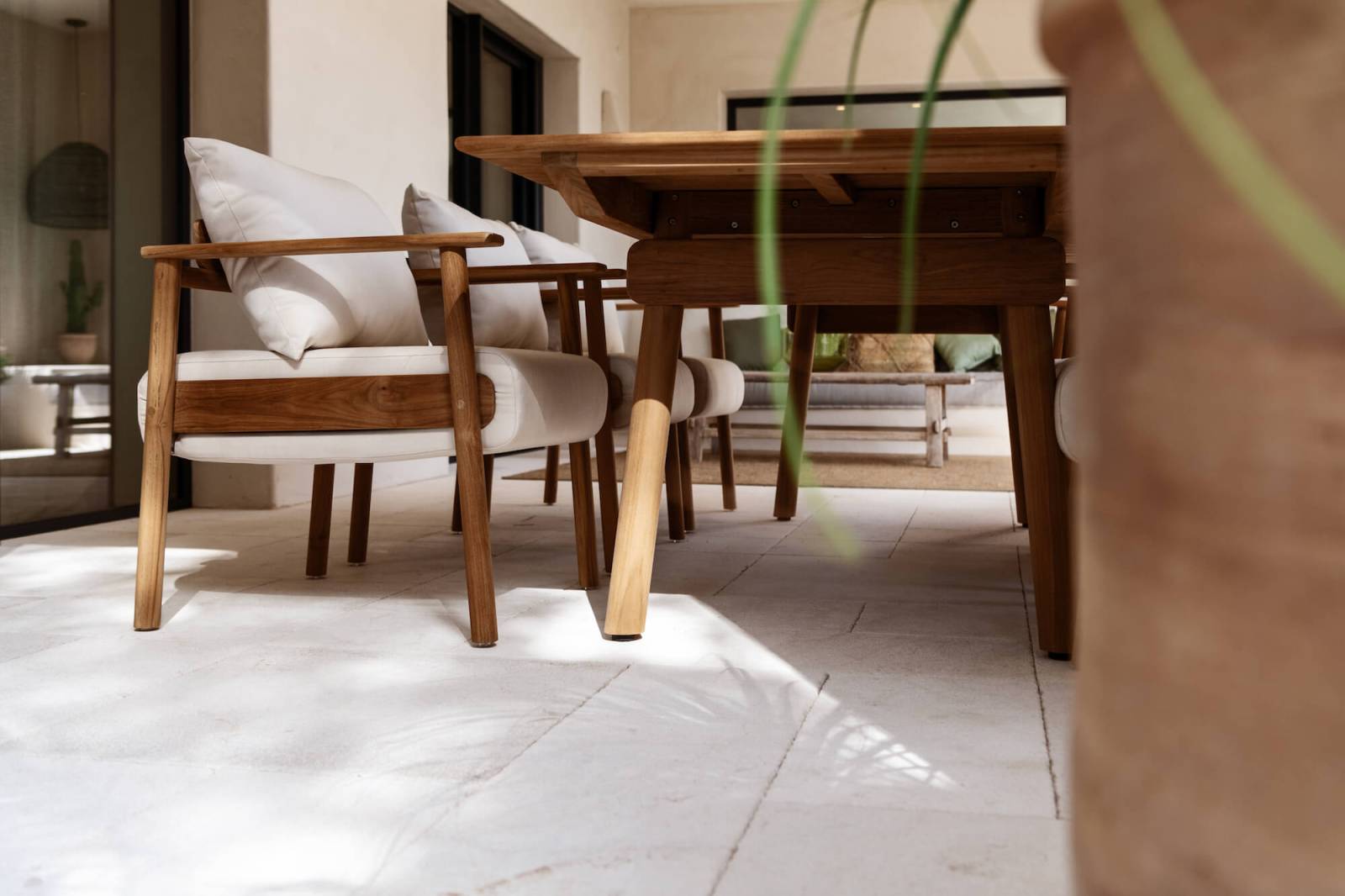 Zoom sur les pieds de la table de repas en teck massif collection Pomalo à Menton
