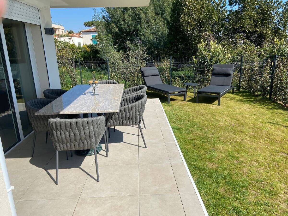 Vue d'ensemble sur un jardin avec chaises de repas et bain de soleil à Marseille