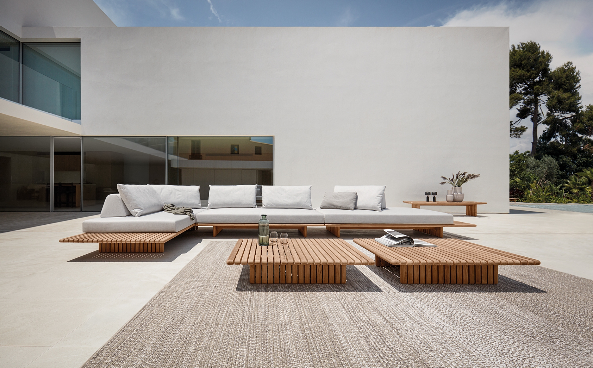 Salon de jardin minimaliste et modulaire en teck naturel et coussins moelleux, collection Deck par Gloster