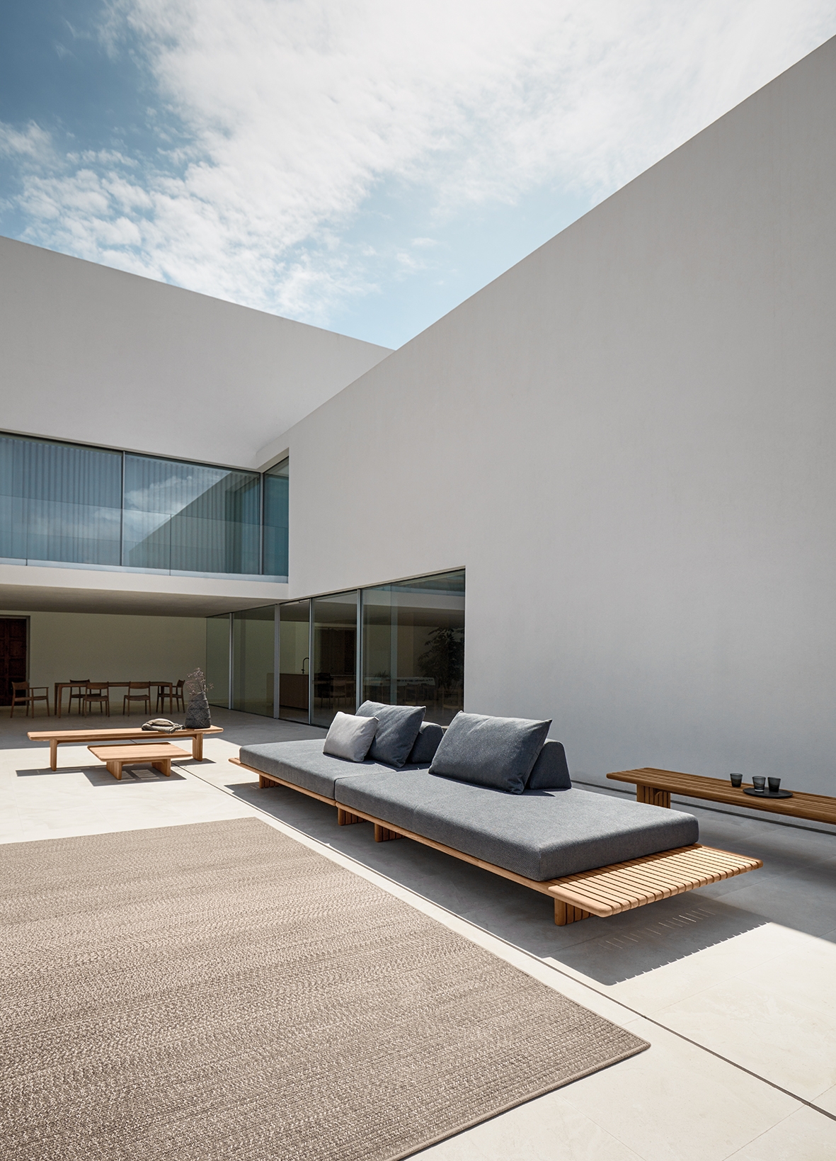 Salon de jardin minimaliste et modulaire en teck naturel et coussins moelleux, collection Deck par Gloster