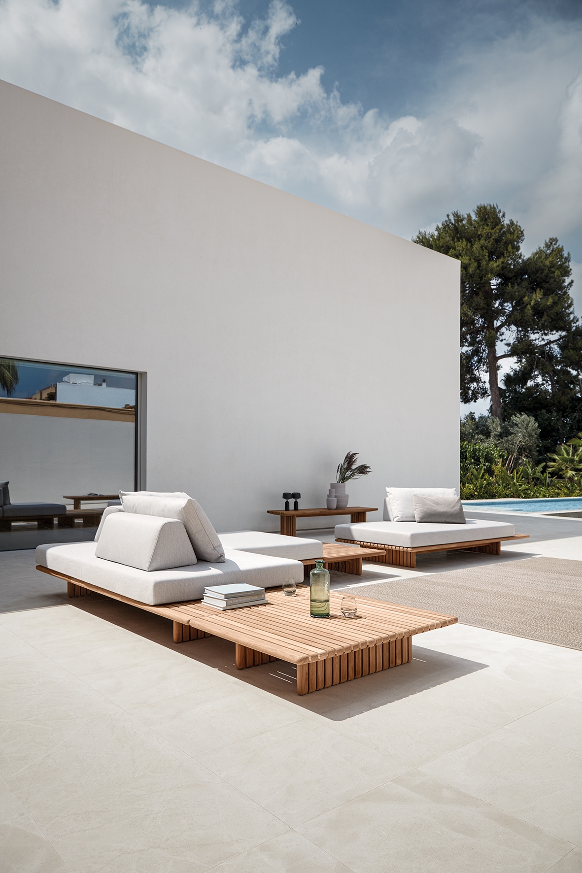 Salon de jardin minimaliste et modulaire en teck naturel et coussins moelleux, collection Deck par Gloster