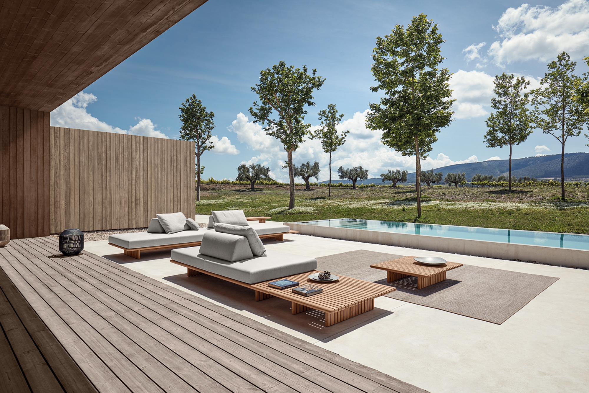 Salon de jardin minimaliste et modulaire en teck naturel et coussins moelleux, collection Deck par Gloster