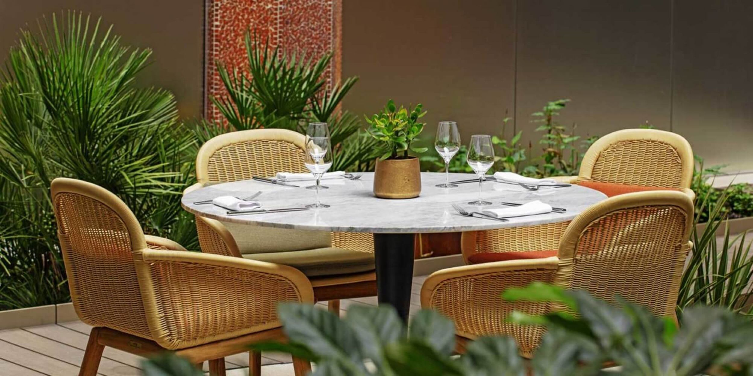 Fauteuil de repas en teck avec une coque tressée collection Vimini par Kettal à Nantes