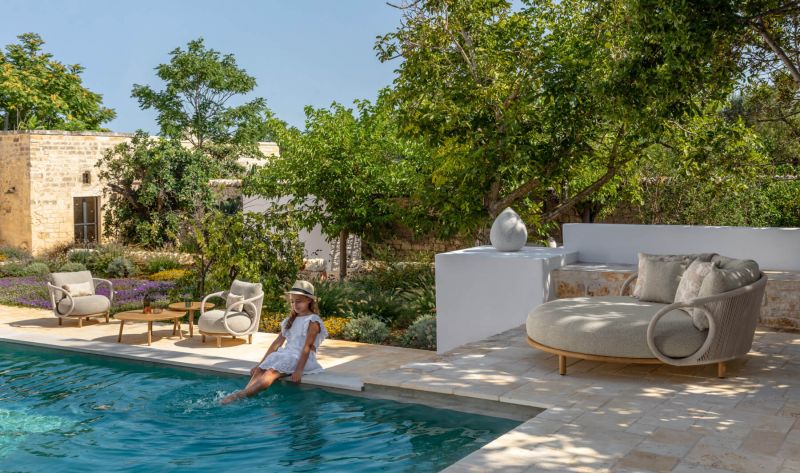 Mobilier extérieur en teck et cordes au bord d'une piscine de la collection Karen par Talenti